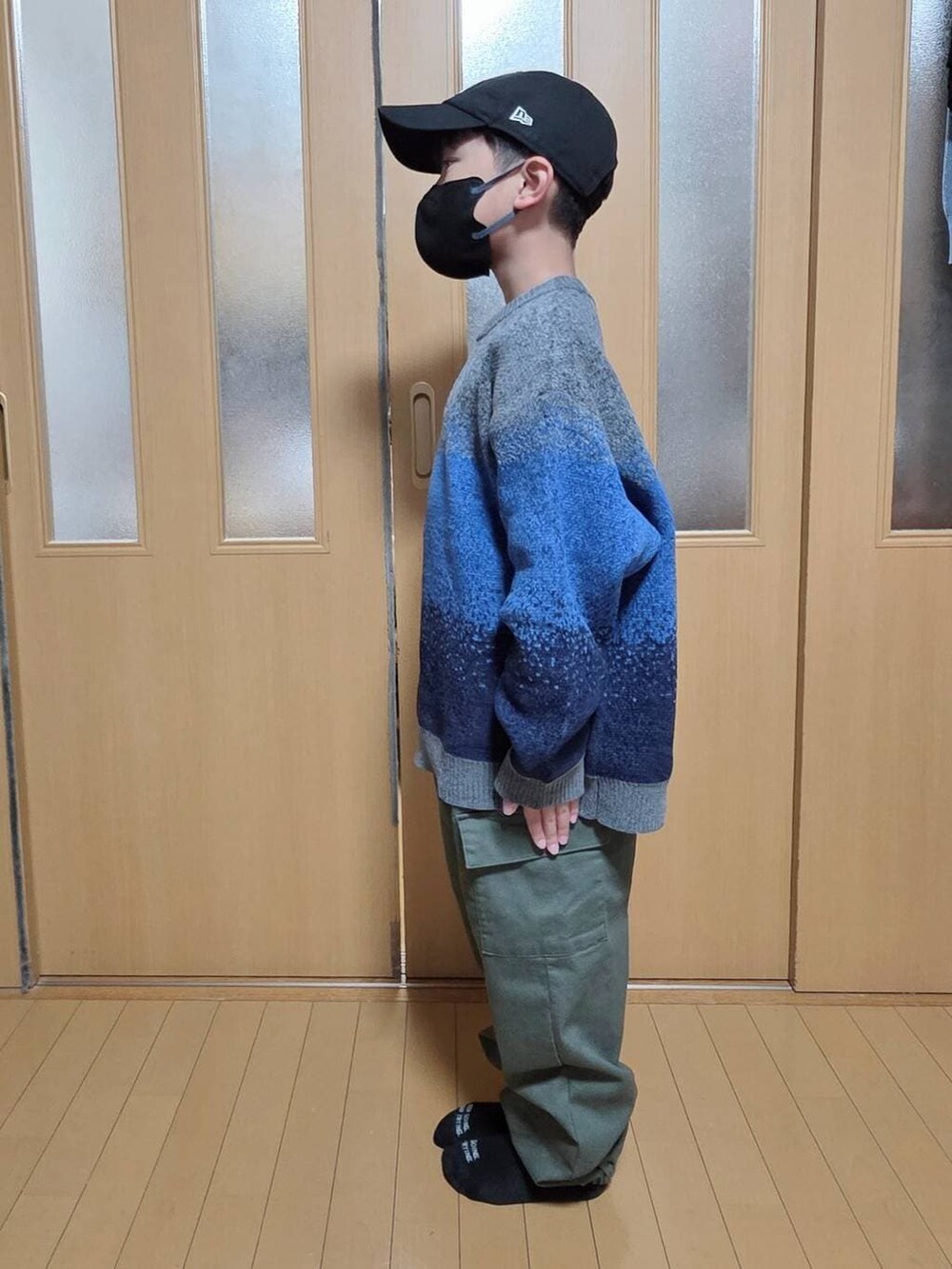 ベージュ系のブルゾン、グリーン系のカーゴパンツ、グレー系のニット/セーターを着用したキッズの冬コーディネートの3枚目の写真