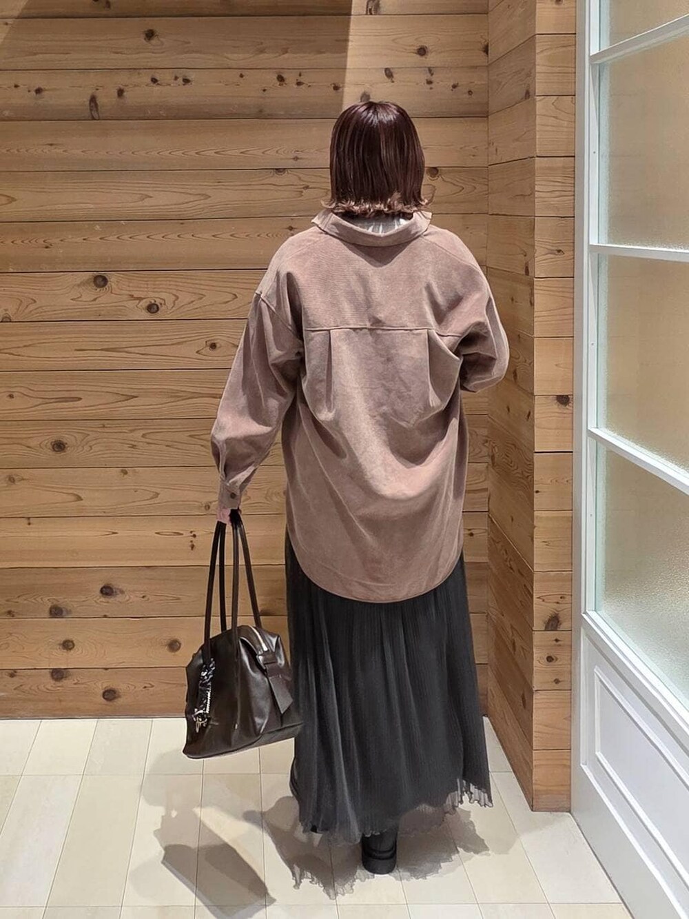 ブラウン系のボストンバッグ、ピンク系のシャツ/ブラウス、グレー系のニット/セーターを着用したレディースの秋コーディネートの3枚目の写真