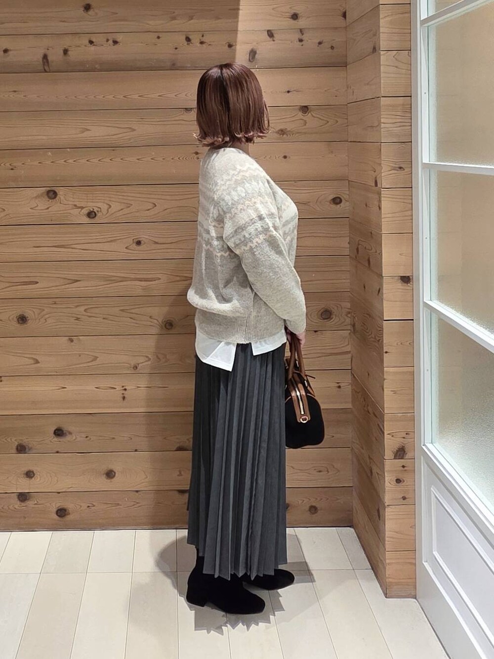 ブラック系のダウンジャケット/コート、グレー系のその他パンツ、ホワイト系のTシャツ/カットソーを着用したレディースの冬コーディネートの2枚目の写真