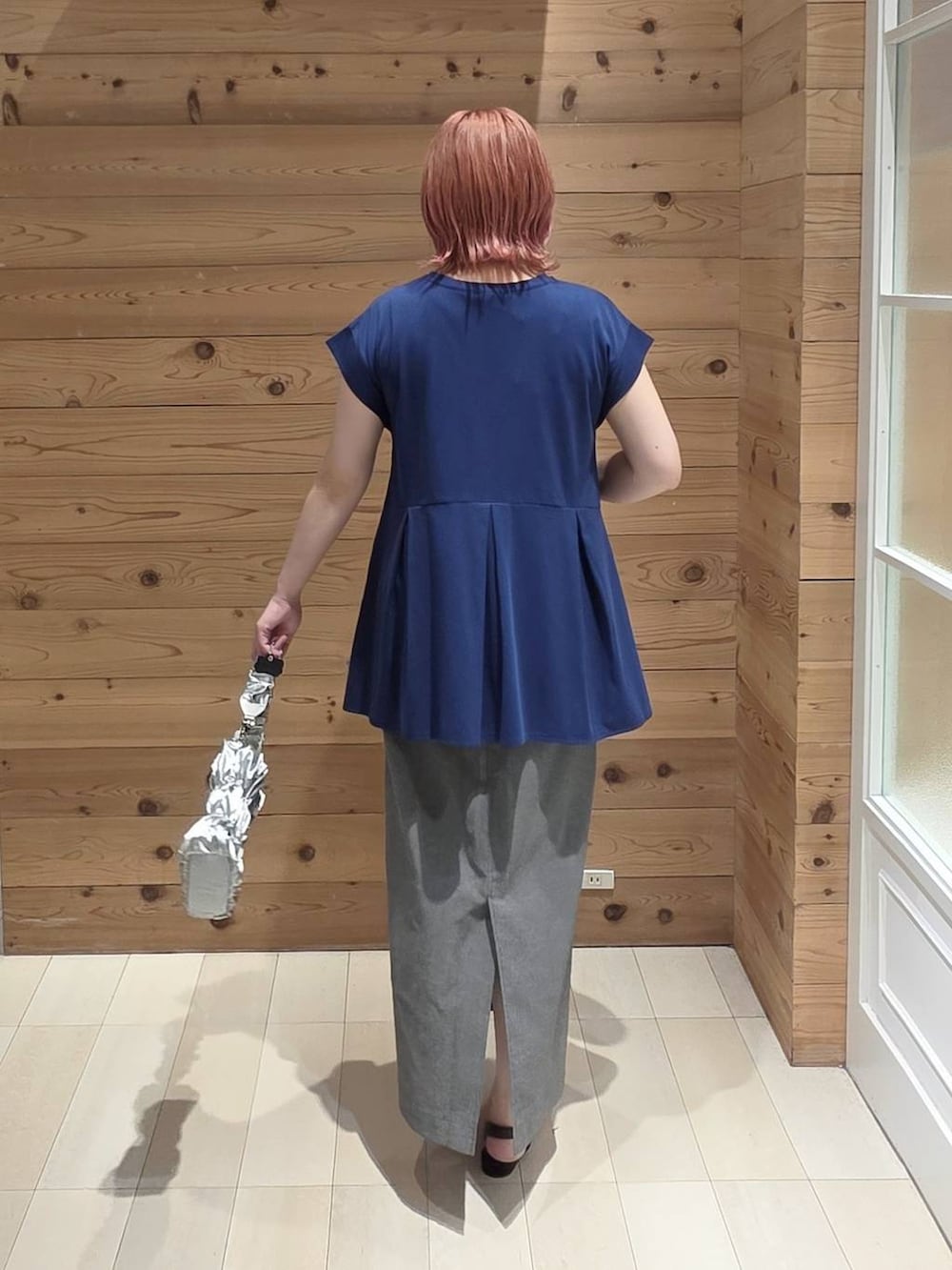 グレー系のスカート、ブルー系のTシャツ/カットソー、シルバー系のショルダーバッグを着用したレディースの夏コーディネートの3枚目の写真