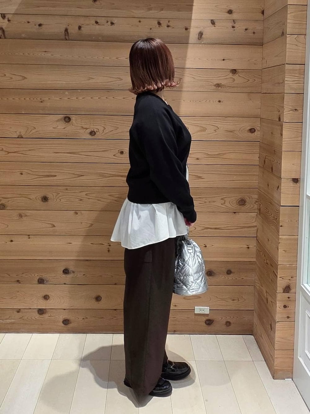 ブラック系のローファー、シルバー系のハンドバッグ、ホワイト系のTシャツ/カットソーを着用したレディースの冬コーディネートの2枚目の写真