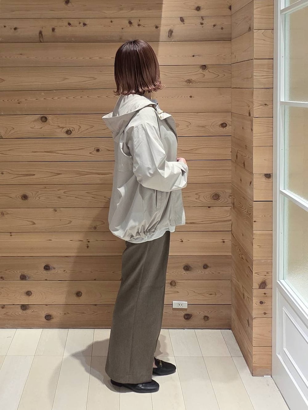 ブラック系のローファー、ブラック系のハンドバッグ、ベージュ系のマウンテンパーカーを着用したレディースの春コーディネートの2枚目の写真