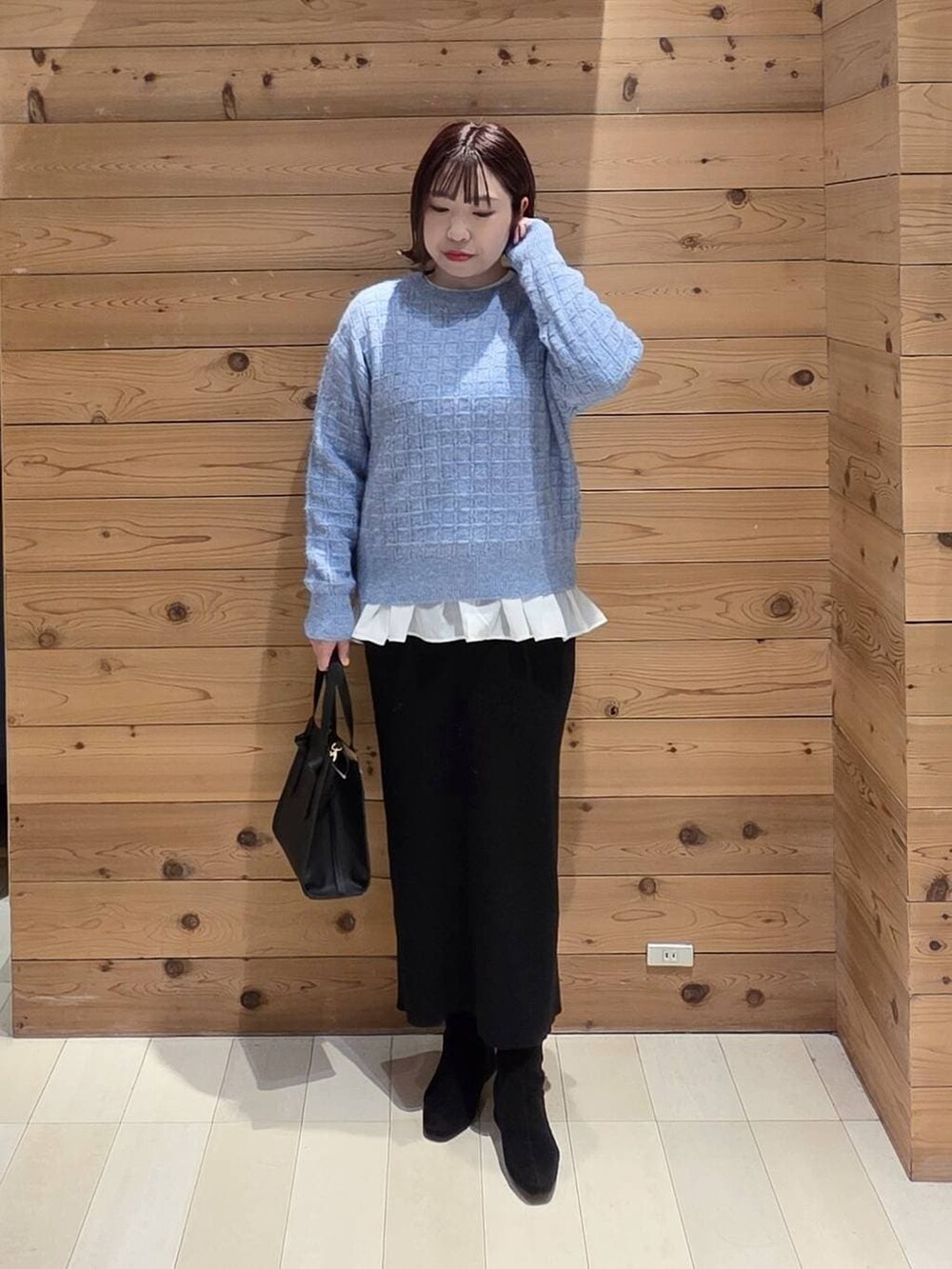 ブラック系のショルダーバッグ、ブラウン系のチェスターコート、ホワイト系のTシャツ/カットソーを着用したレディースの冬コーディネートの4枚目の写真