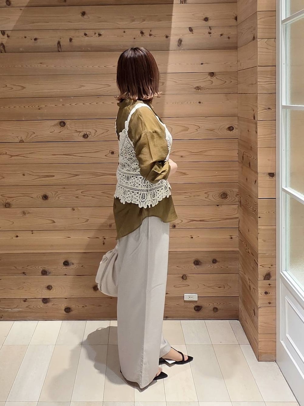 ホワイト系のショルダーバッグ、ベージュ系のその他パンツ、ホワイト系のタンクトップを着用したレディースの夏コーディネートの2枚目の写真