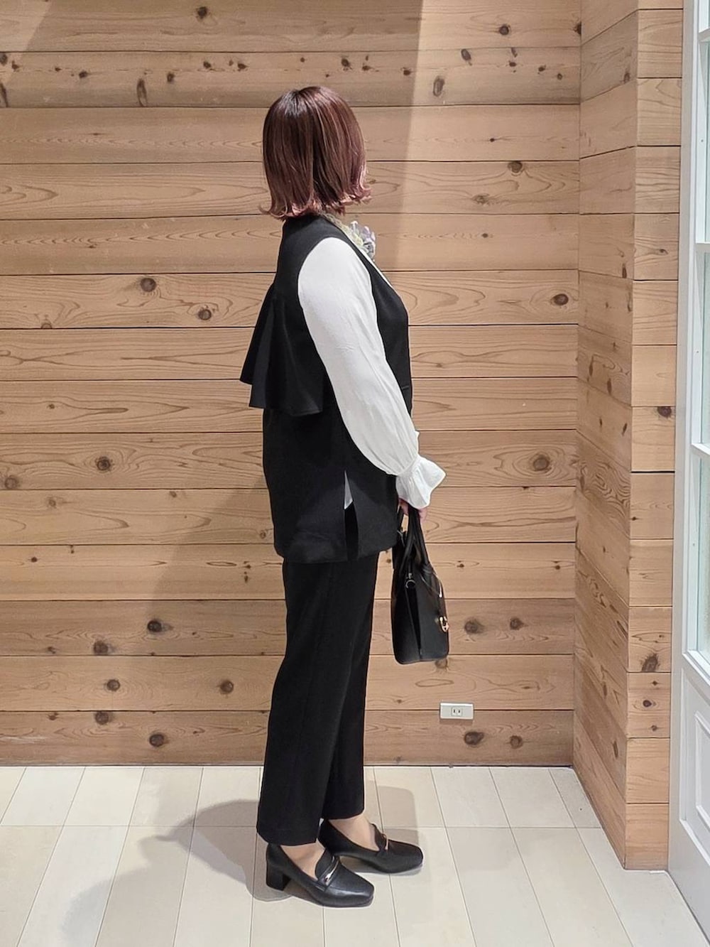 ブラック系のローファー、ブラック系のショルダーバッグ、ブラック系のセットアップを着用したレディースの冬コーディネートの2枚目の写真