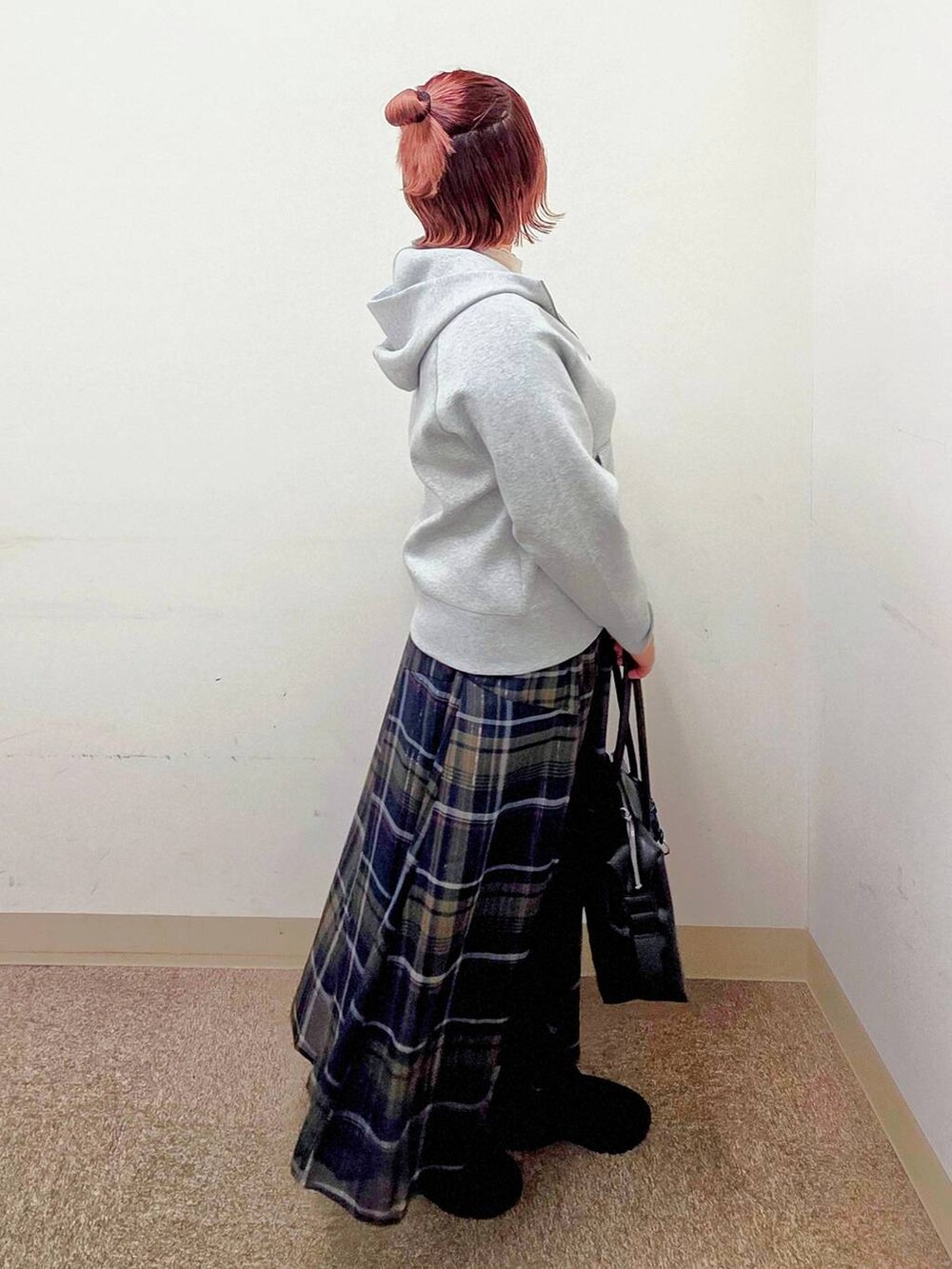 ブラック系のボストンバッグ、その他のスカート、ブラック系のブーツを着用したレディースの秋コーディネートの2枚目の写真