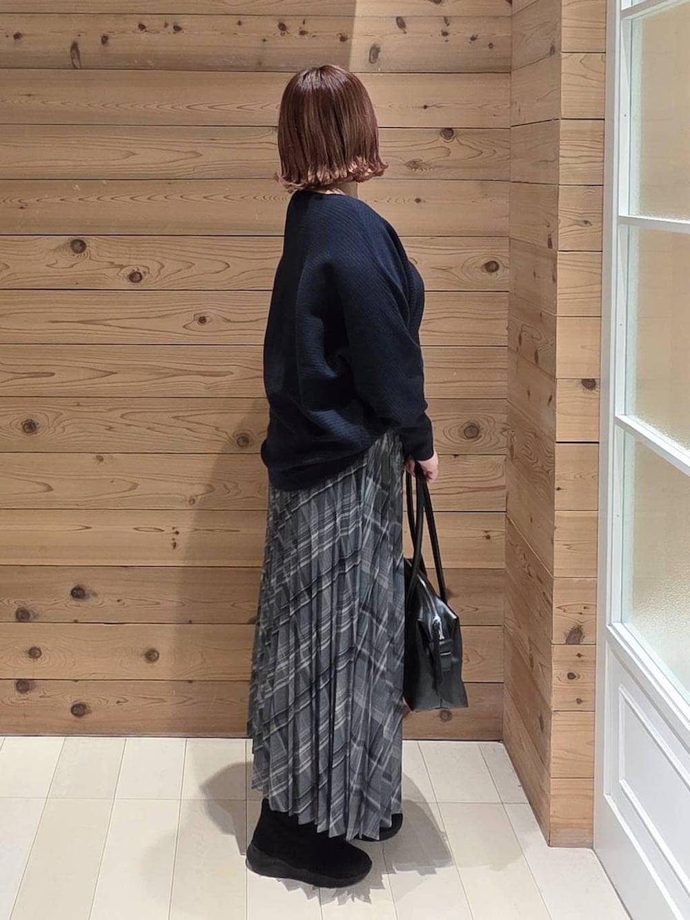 ベージュ系のダウンジャケット/コート、ブラック系のボストンバッグ、ブラック系のブーツを着用したレディースの冬コーディネートの2枚目の写真