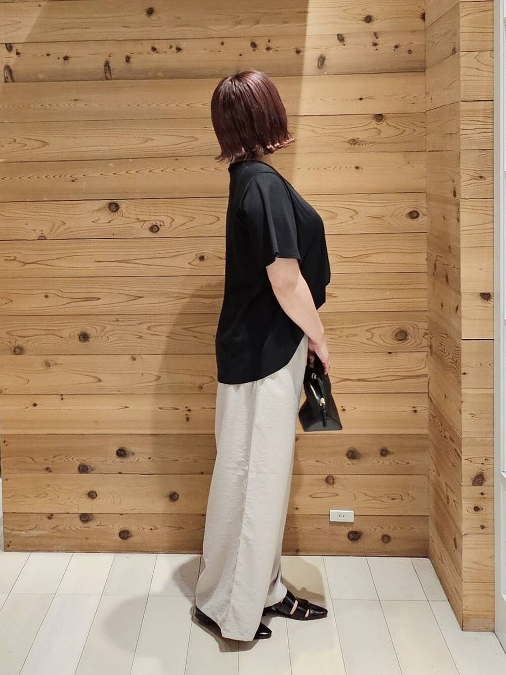 ブラック系のショルダーバッグ、ブラック系のTシャツ/カットソー、ブラック系のパンプスを着用したレディースの夏コーディネートの2枚目の写真