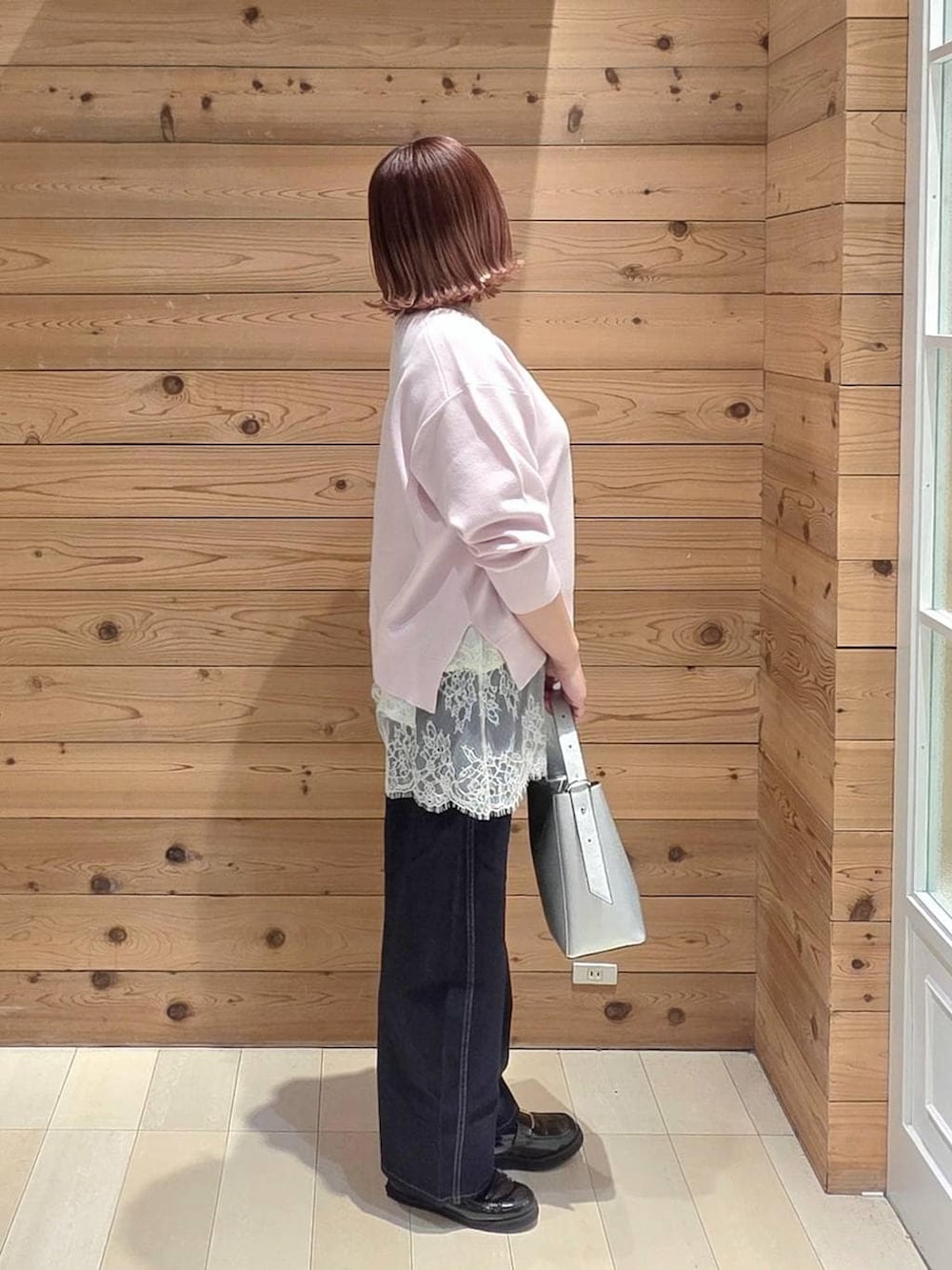 ブラック系のローファー、シルバー系のショルダーバッグ、ブルー系のデニムパンツを着用したレディースの春コーディネートの2枚目の写真