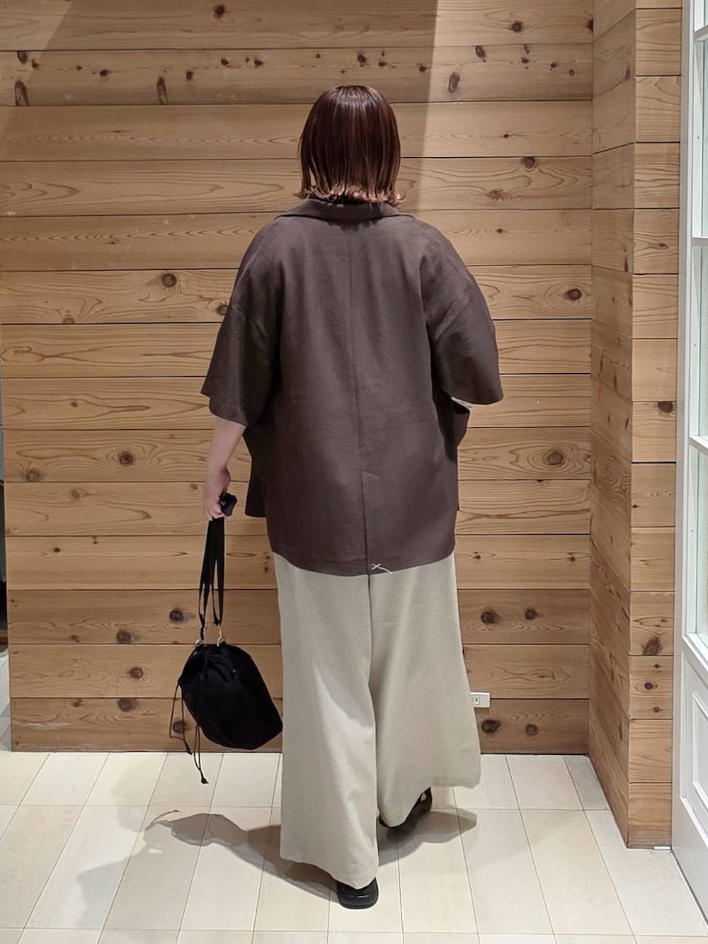 ブラウン系のテーラードジャケット、ホワイト系のTシャツ/カットソー、ブラック系のサンダルを着用したレディースの春コーディネートの3枚目の写真
