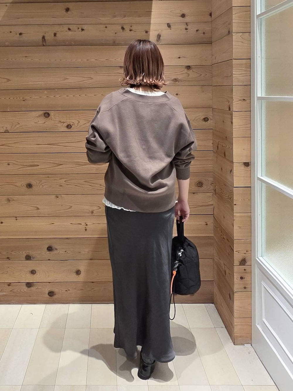 ブラック系のローファー、ブラック系のハンドバッグ、ホワイト系のパーカーを着用したレディースの春コーディネートの3枚目の写真