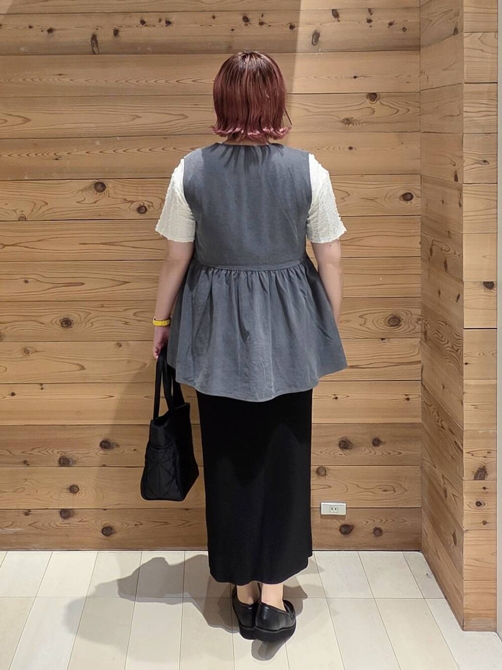 ブラック系のローファー、ブラック系のトートバッグ、ベージュ系のTシャツ/カットソーを着用したレディースの夏コーディネートの3枚目の写真