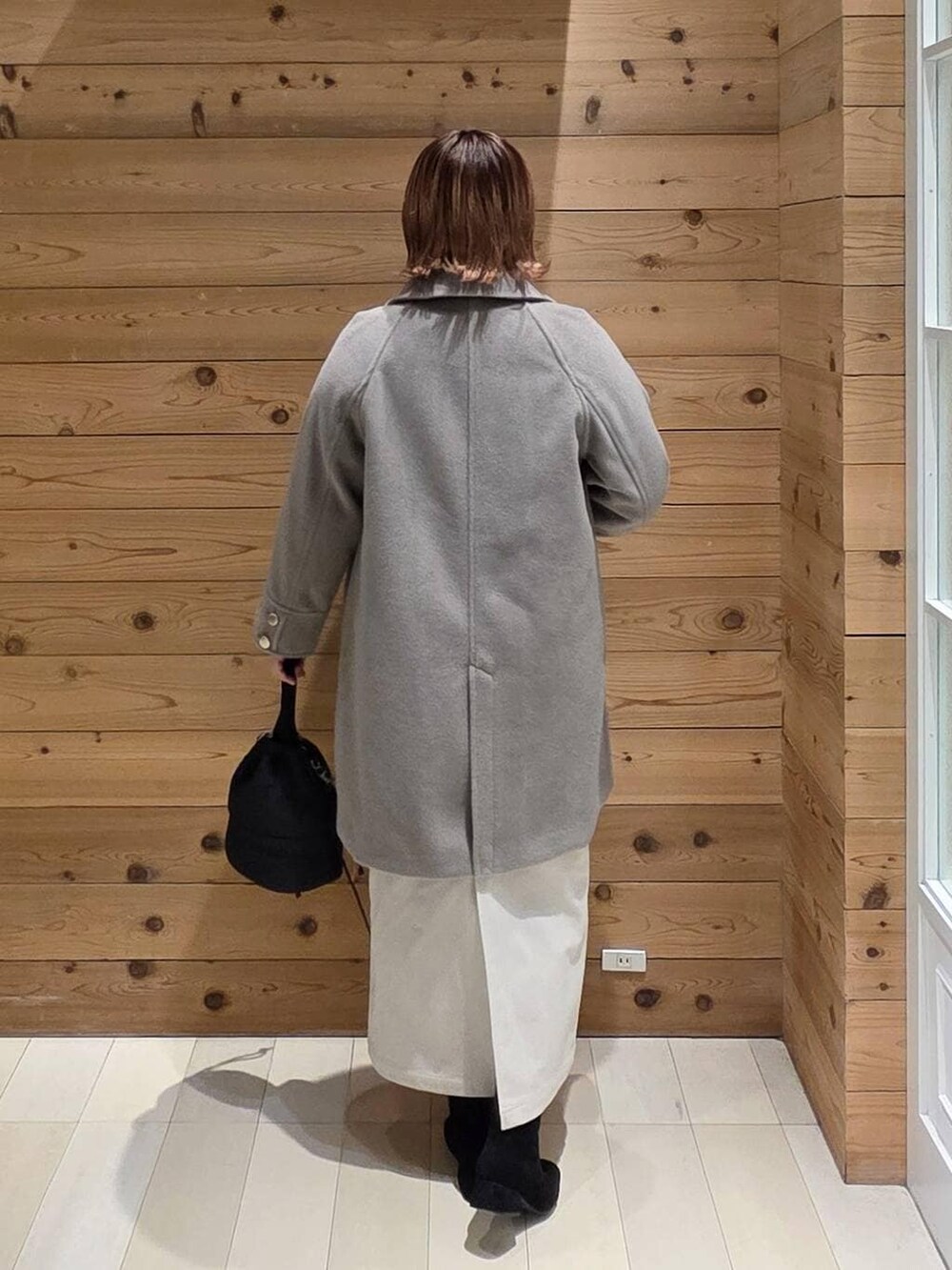 ベージュ系のチェスターコート、グレー系のスカート、ブラック系のハンドバッグを着用したレディースの冬コーディネートの3枚目の写真