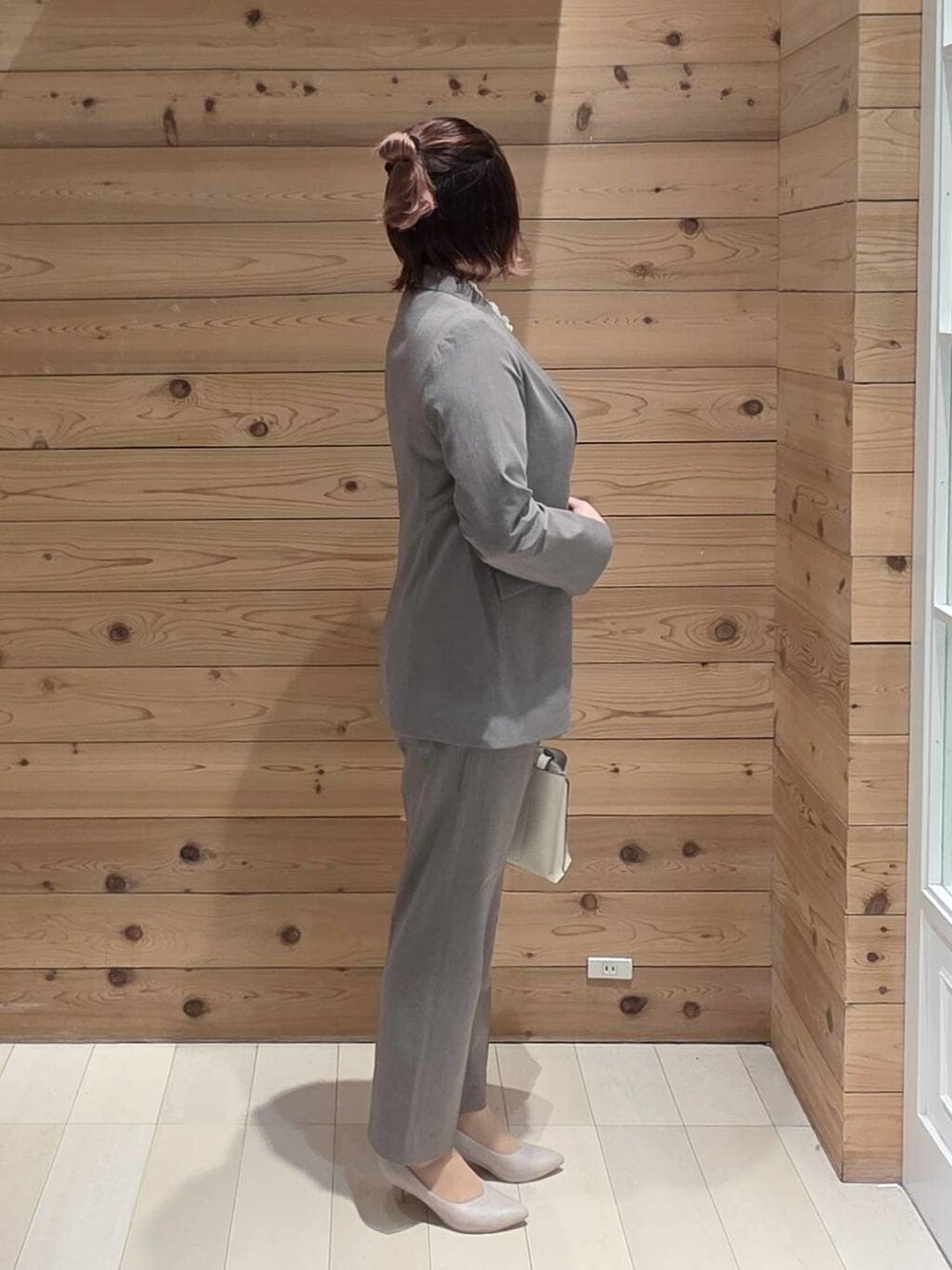 ホワイト系のパンプス、ブラウン系のスラックス、ブルー系のシャツ/ブラウスを着用したレディースの冬コーディネートの2枚目の写真