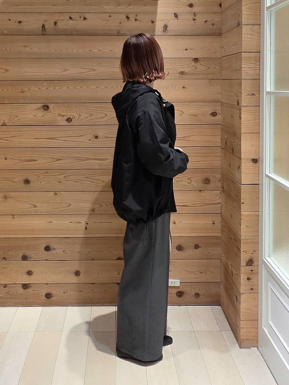 ブラック系のパンプス、ホワイト系のショルダーバッグ、ブラック系のマウンテンパーカーを着用したレディースの春コーディネートの2枚目の写真