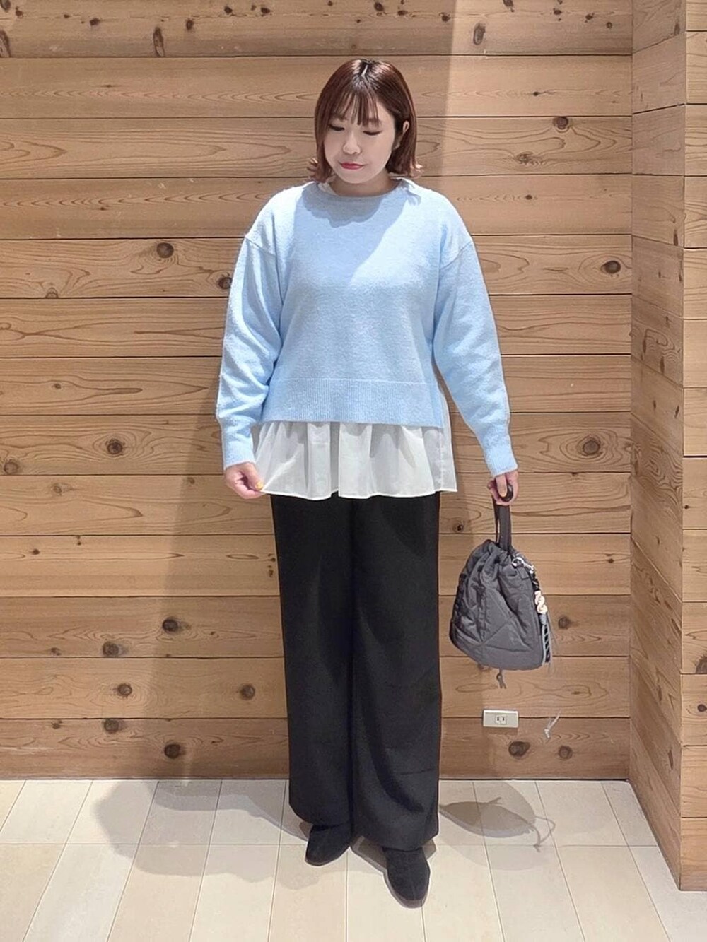 ベージュ系のブルゾン、グレー系のハンドバッグ、ブルー系のニット/セーターを着用したレディースの冬コーディネートの4枚目の写真