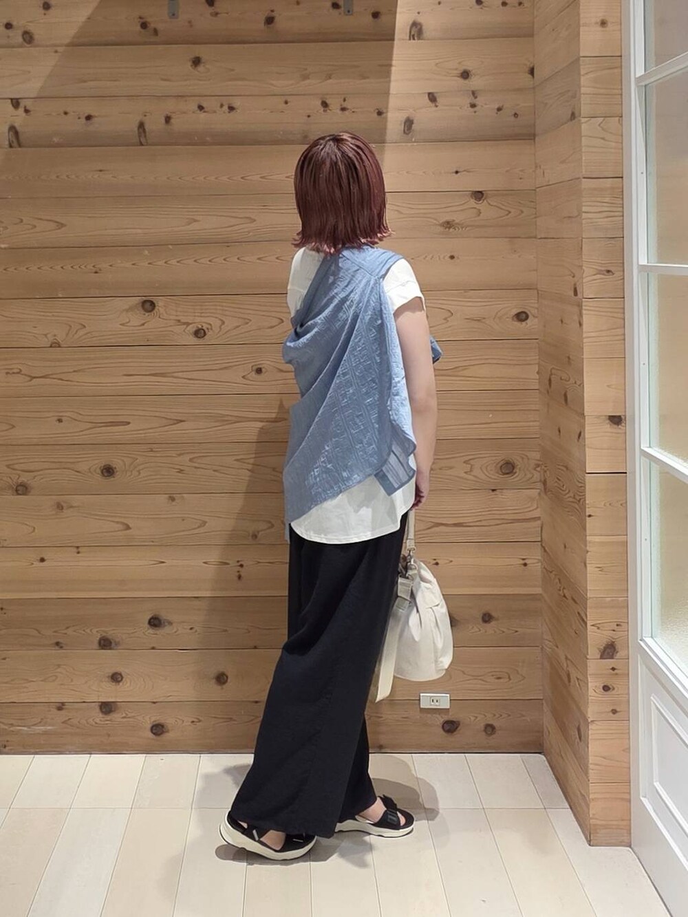 ホワイト系のショルダーバッグ、ブルー系のシャツ/ブラウス、ブラック系のサンダルを着用したレディースの夏コーディネートの2枚目の写真
