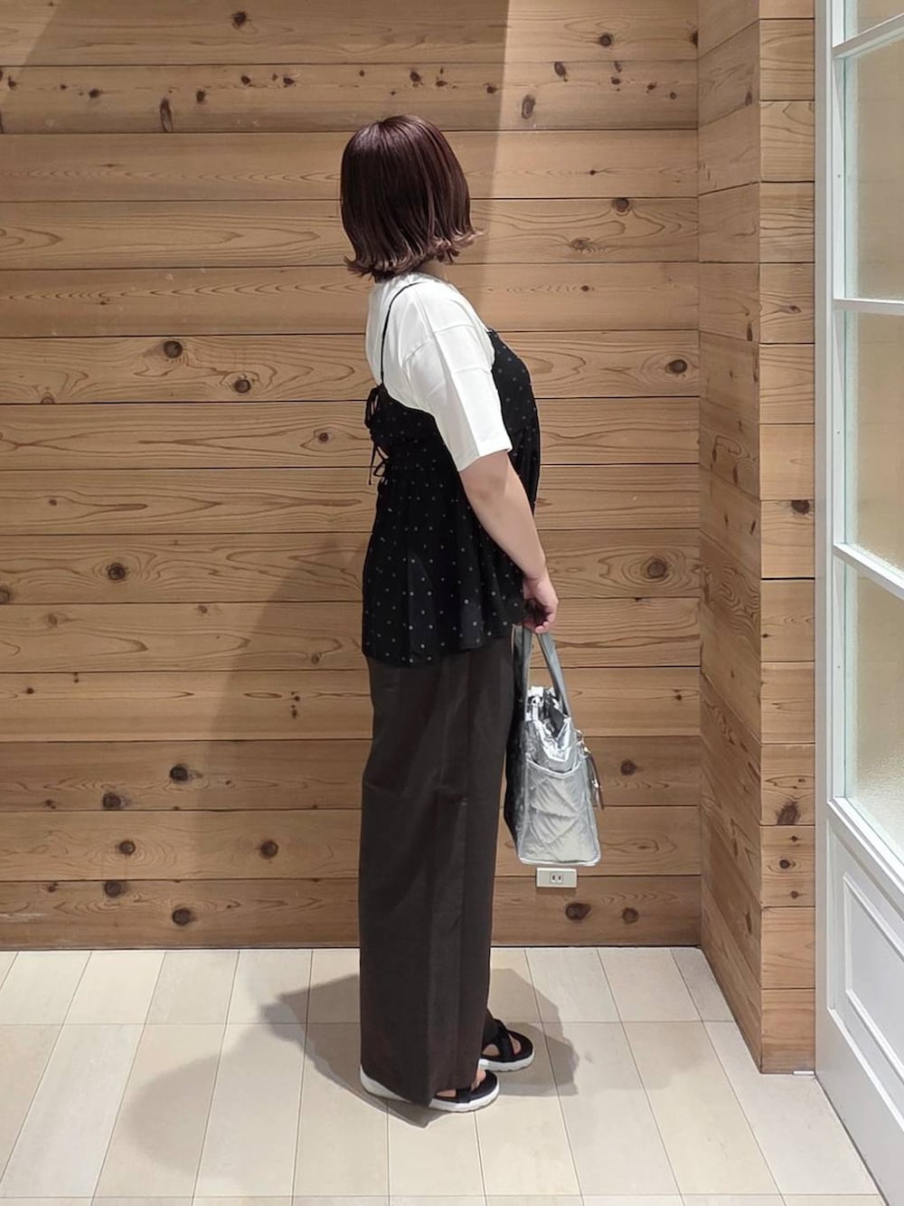 シルバー系のトートバッグ、ブラウン系のその他パンツ、ブラック系のその他パンツを着用したレディースの春コーディネートの2枚目の写真