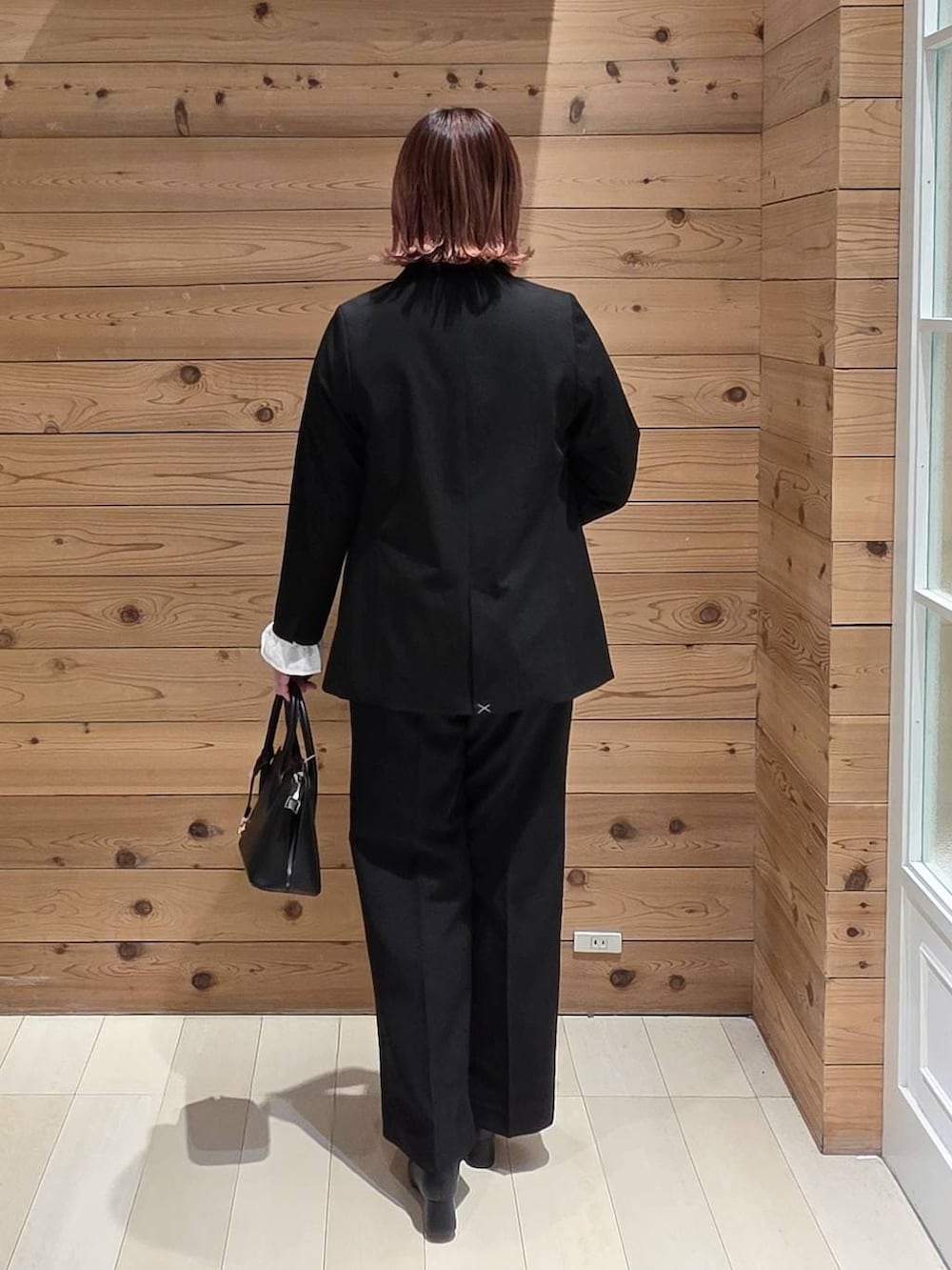 ブラック系のローファー、ブラック系のショルダーバッグ、ブラック系のテーラードジャケットを着用したレディースの冬コーディネートの3枚目の写真