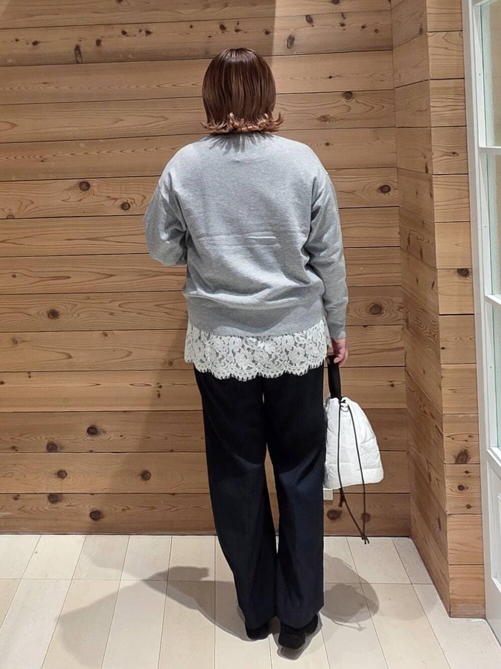 ブラウン系のダウンジャケット/コート、ホワイト系のハンドバッグ、ブルー系のその他パンツを着用したレディースの冬コーディネートの3枚目の写真