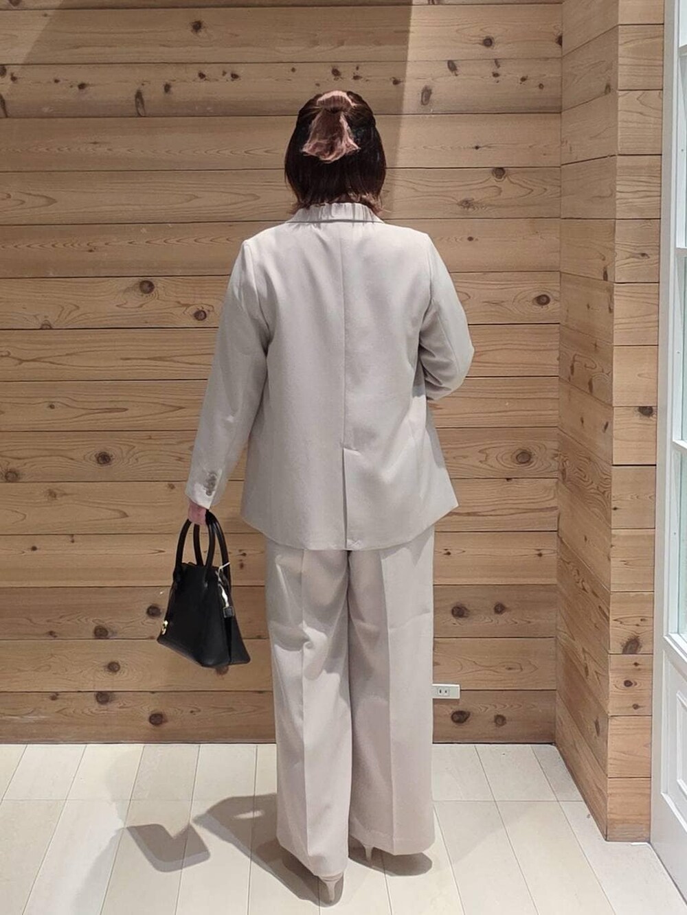 ブラック系のショルダーバッグ、ホワイト系のパンプス、ブルー系のシャツ/ブラウスを着用したレディースの冬コーディネートの3枚目の写真