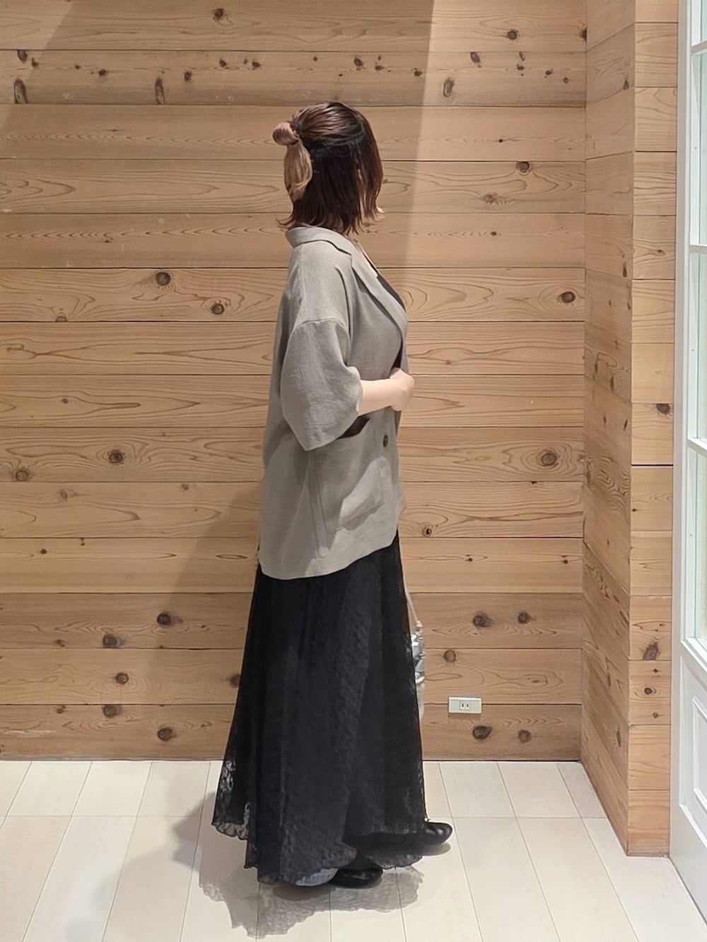 ブラック系のバレエシューズ、ブルー系のデニムパンツ、ブラウン系のテーラードジャケットを着用したレディースの夏コーディネートの2枚目の写真