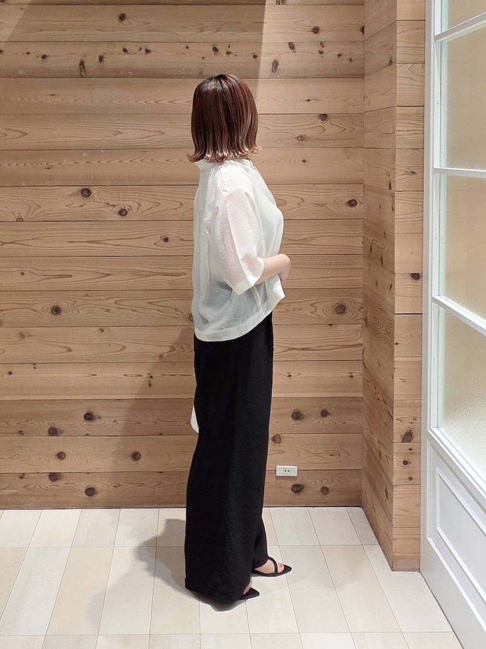 ホワイト系のハンドバッグ、ブラック系のその他パンツ、ホワイト系のシャツ/ブラウスを着用したレディースの夏コーディネートの2枚目の写真