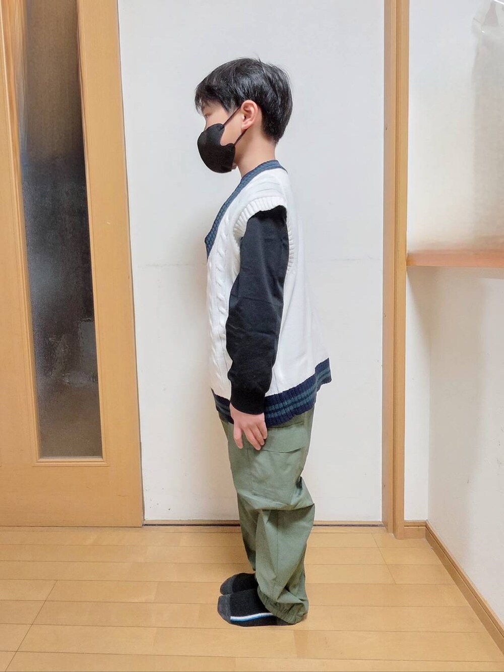 ブラック系のTシャツ/カットソー、グリーン系のカーゴパンツ、ベージュ系のベストを着用したキッズの冬コーディネートの2枚目の写真