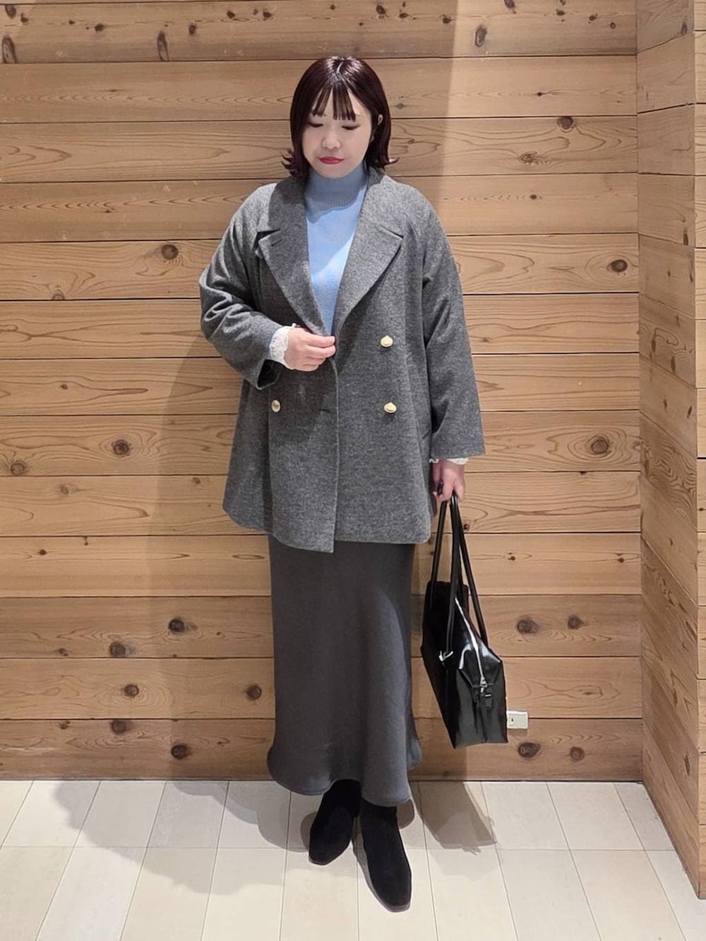 ブラック系のボストンバッグ、グレー系のチェスターコート、ホワイト系のTシャツ/カットソーを着用したレディースの冬コーディネートの4枚目の写真