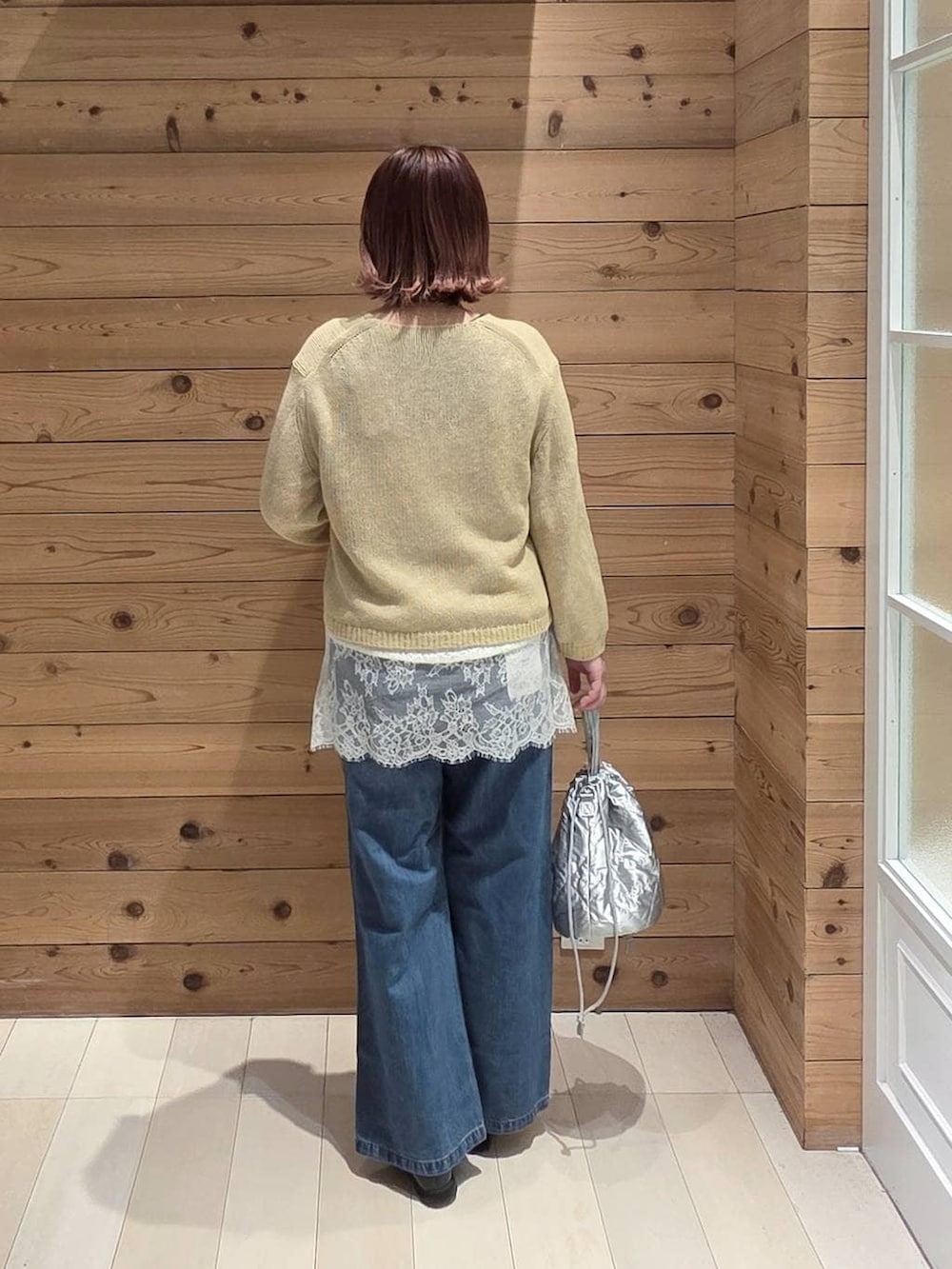 ブラック系のローファー、ブルー系のデニムパンツ、シルバー系のハンドバッグを着用したレディースの春コーディネートの3枚目の写真