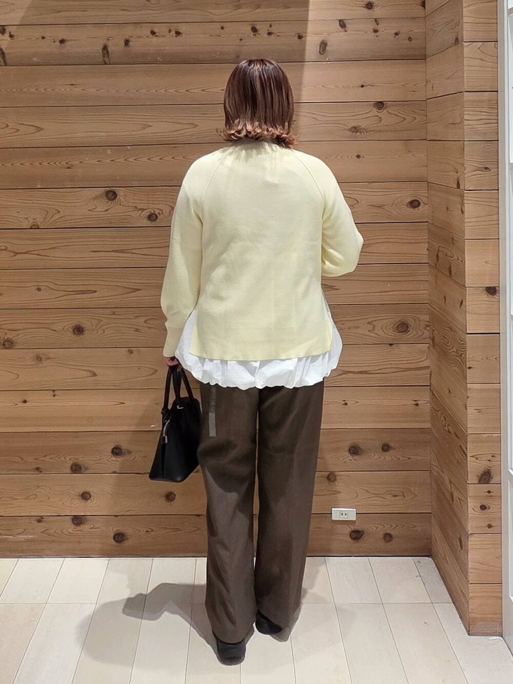 ブラック系のショルダーバッグ、ベージュ系のダウンジャケット/コート、ブラック系のブーツを着用したレディースの冬コーディネートの3枚目の写真