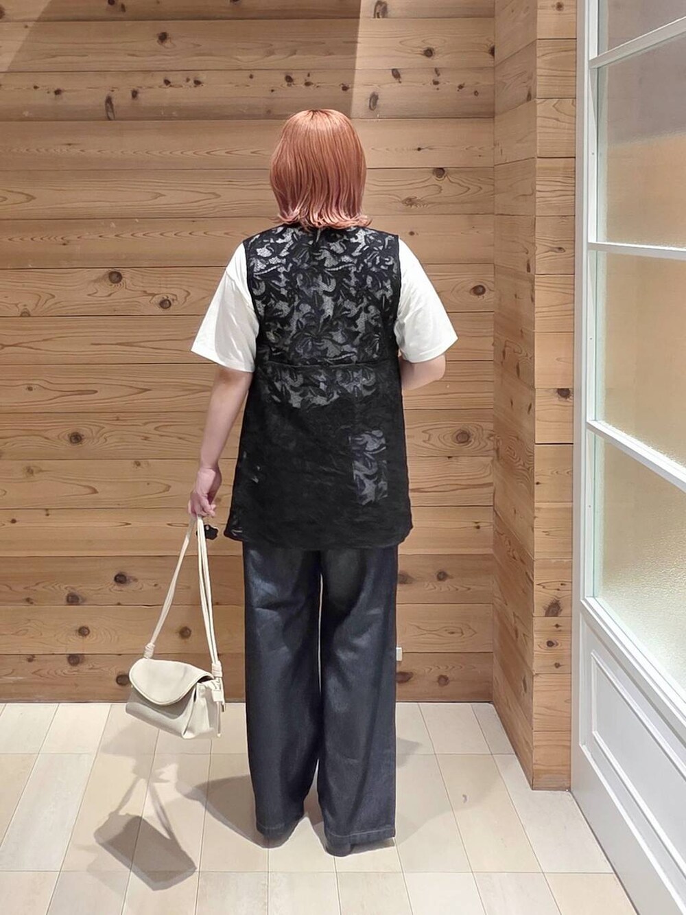 ブラック系のベスト、ベージュ系のショルダーバッグ、ホワイト系のTシャツ/カットソーを着用したレディースの夏コーディネートの3枚目の写真