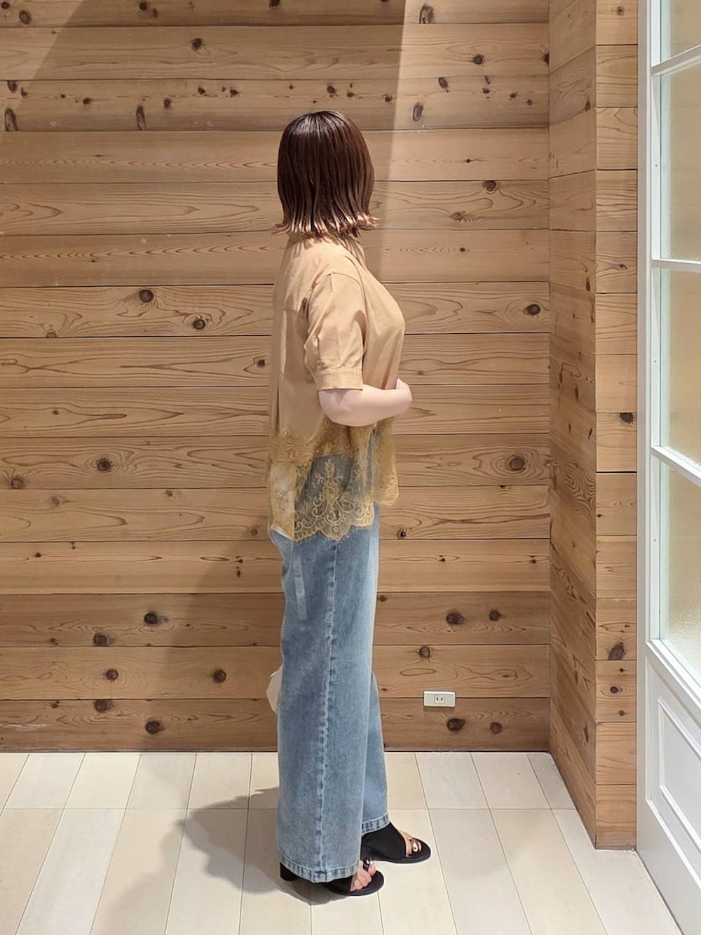 ブルー系のデニムパンツ、ホワイト系のタンクトップ、ブラック系のサンダルを着用したレディースの夏コーディネートの2枚目の写真