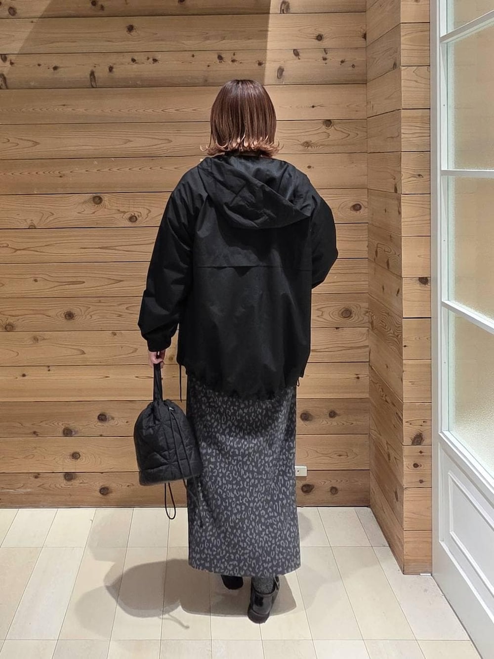 ブラック系のローファー、ブラック系のハンドバッグ、ブラック系のマウンテンパーカーを着用したレディースの春コーディネートの3枚目の写真