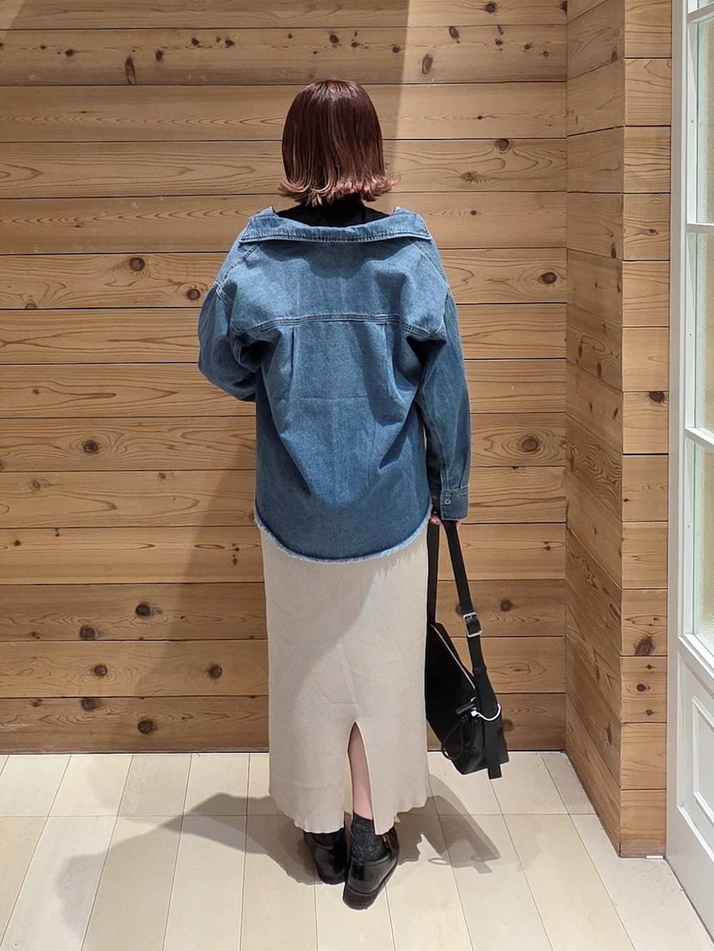 ブラック系のローファー、ブラック系のニット/セーター、ブルー系のシャツ/ブラウスを着用したレディースの春コーディネートの3枚目の写真