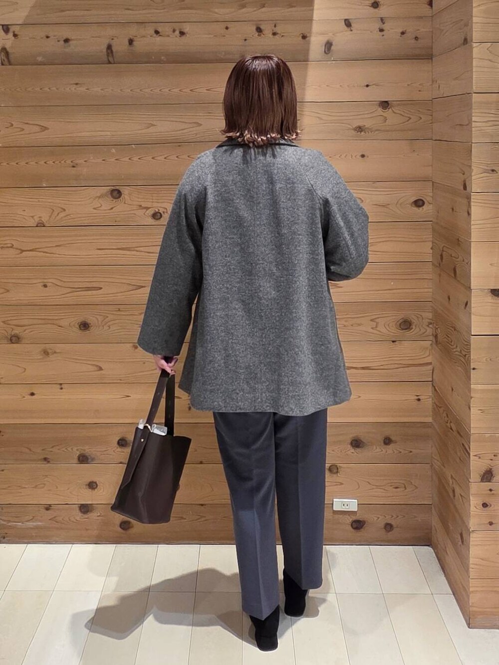 ブラウン系のショルダーバッグ、グレー系のその他パンツ、グレー系のチェスターコートを着用したレディースの秋コーディネートの3枚目の写真