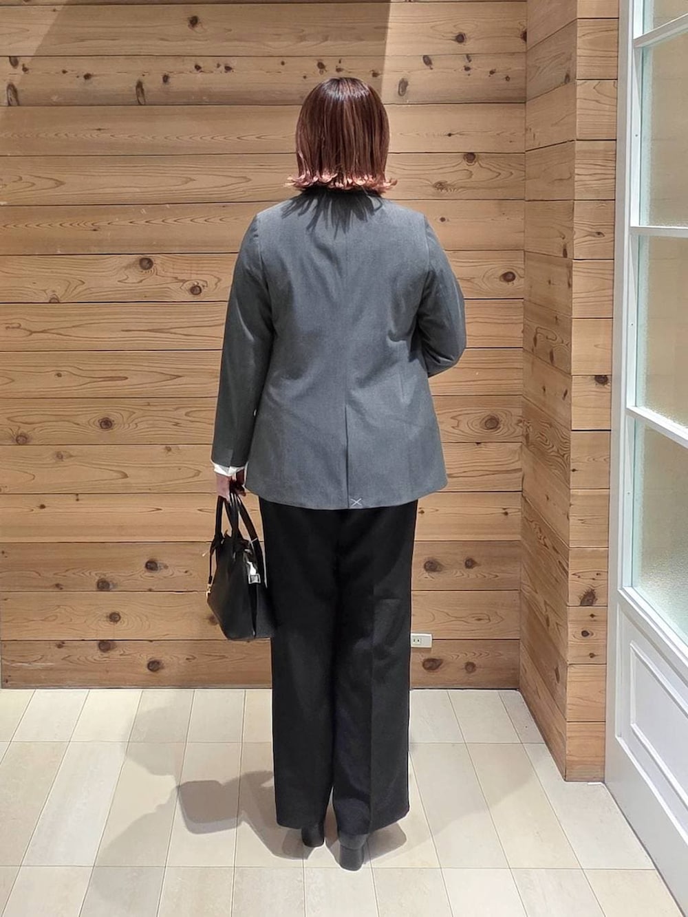 ブラック系のローファー、ブラック系のショルダーバッグ、グレー系のテーラードジャケットを着用したレディースの冬コーディネートの3枚目の写真