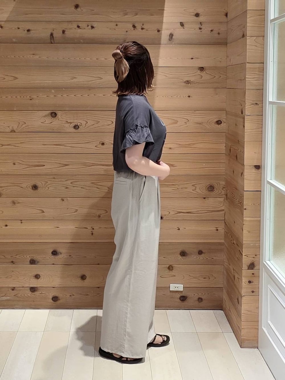 ベージュ系のその他パンツ、ブラック系のTシャツ/カットソー、ブラック系のサンダルを着用したレディースの夏コーディネートの2枚目の写真