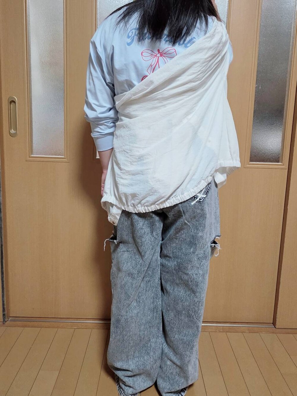 ブラック系のデニムパンツ、ホワイト系のマウンテンパーカー、ブルー系のTシャツ/カットソーを着用したキッズの秋コーディネートの2枚目の写真