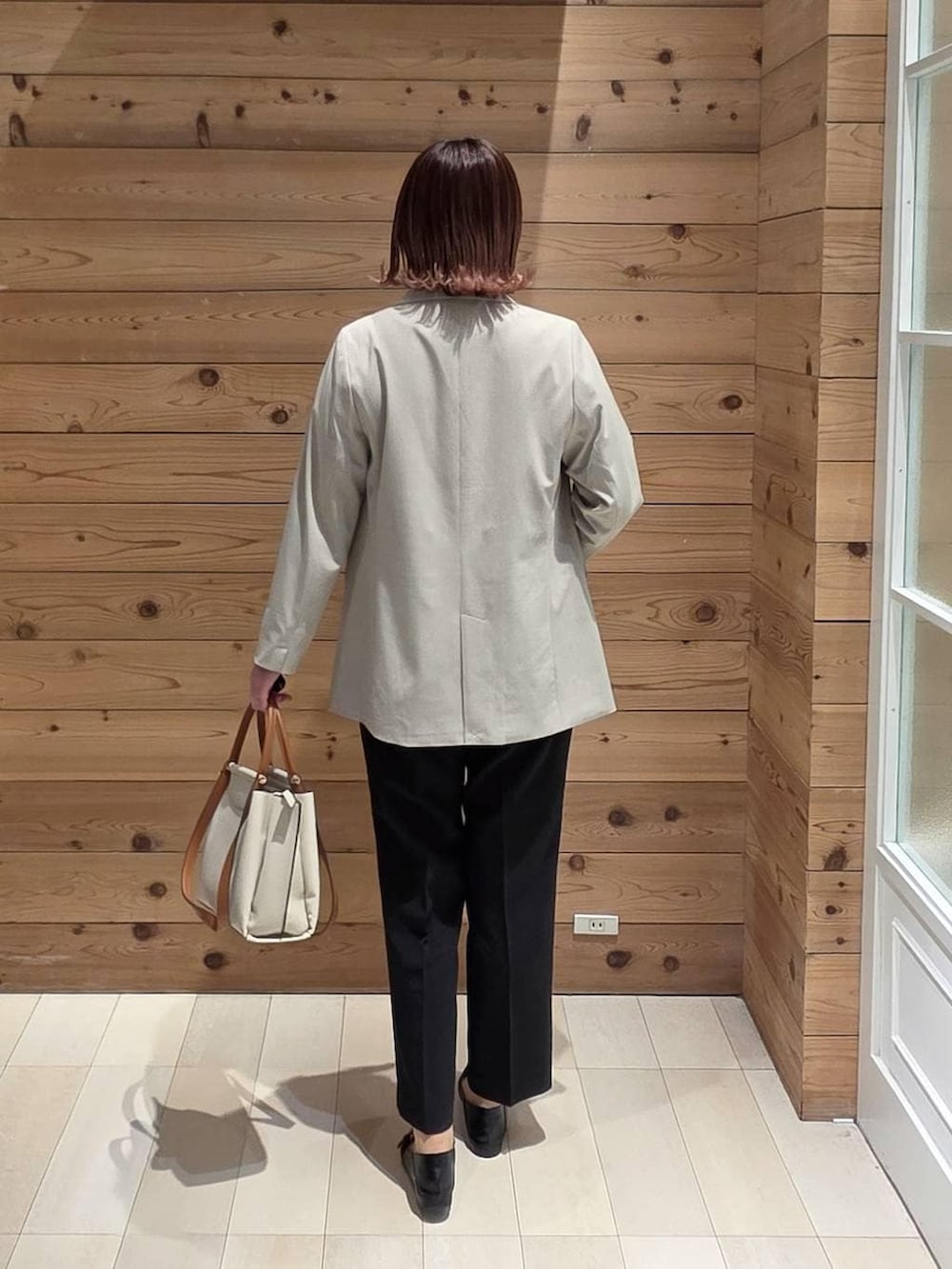 ブラック系のローファー、ブルー系のシャツ/ブラウス、ホワイト系のトートバッグを着用したレディースの春コーディネートの3枚目の写真