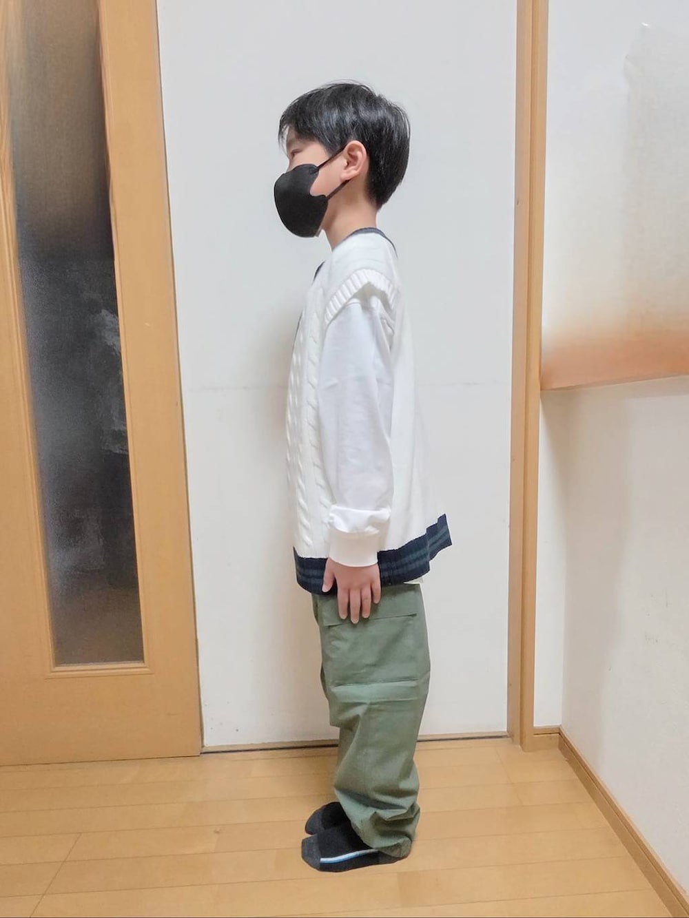 グリーン系のカーゴパンツ、ベージュ系のベスト、ホワイト系のTシャツ/カットソーを着用したキッズの春コーディネートの2枚目の写真