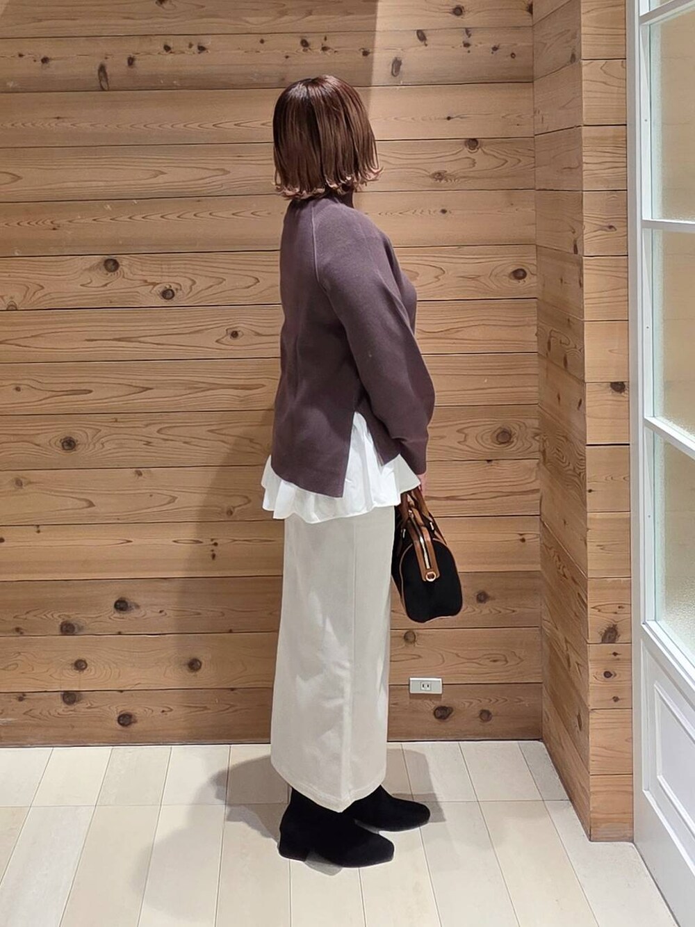 グレー系のブルゾン、グレー系のスカート、ホワイト系のTシャツ/カットソーを着用したレディースの冬コーディネートの2枚目の写真