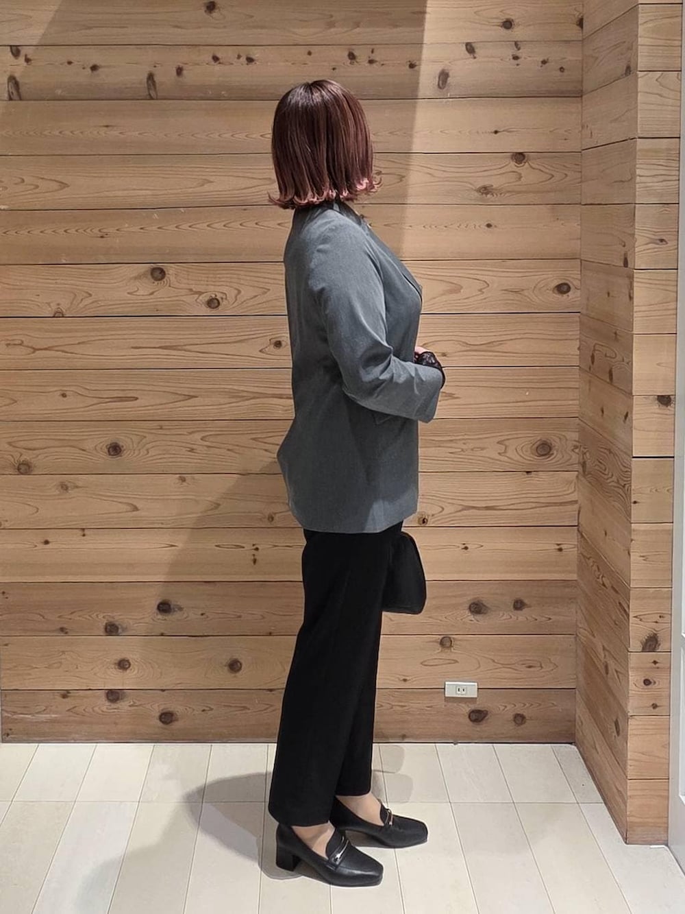 ブラック系のローファー、ブラック系のショルダーバッグ、ブラック系のTシャツ/カットソーを着用したレディースの冬コーディネートの2枚目の写真