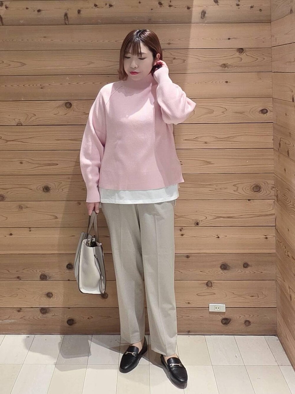 ブラック系のローファー、ホワイト系のショルダーバッグ、ブラック系のダウンジャケット/コートを着用したレディースの冬コーディネートの4枚目の写真