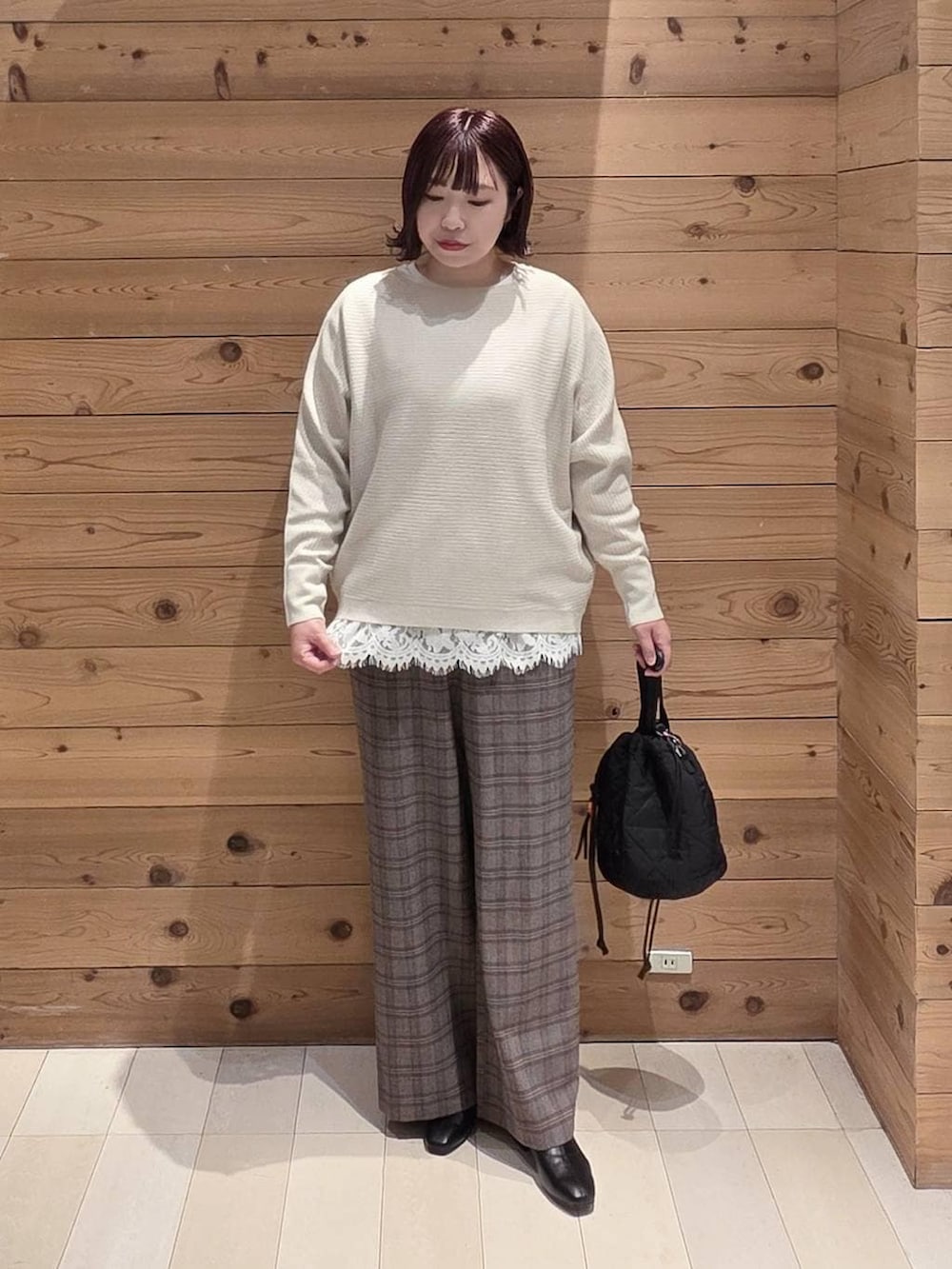 ブラック系のダウンジャケット/コート、ブラック系のハンドバッグ、ホワイト系のTシャツ/カットソーを着用したレディースの冬コーディネートの4枚目の写真