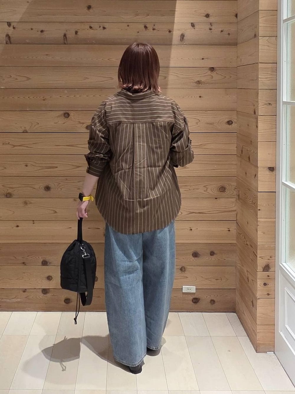 ブラック系のローファー、ブラック系のハンドバッグ、ブラウン系のシャツ/ブラウスを着用したレディースの春コーディネートの3枚目の写真