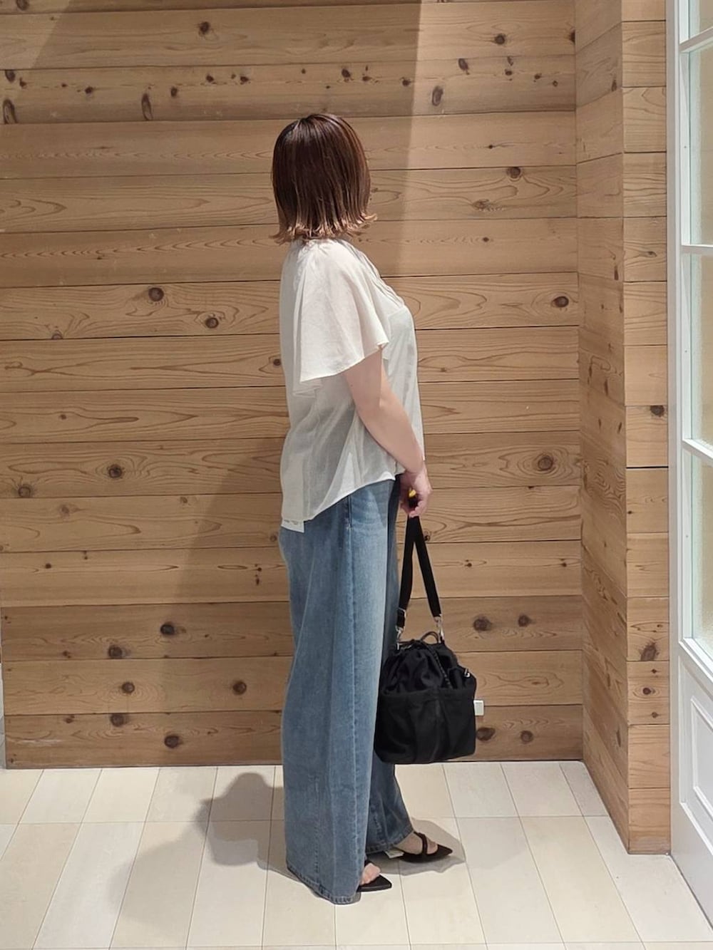 ベージュ系のシャツ/ブラウス、ブルー系のデニムパンツ、ホワイト系のタンクトップを着用したレディースの夏コーディネートの2枚目の写真