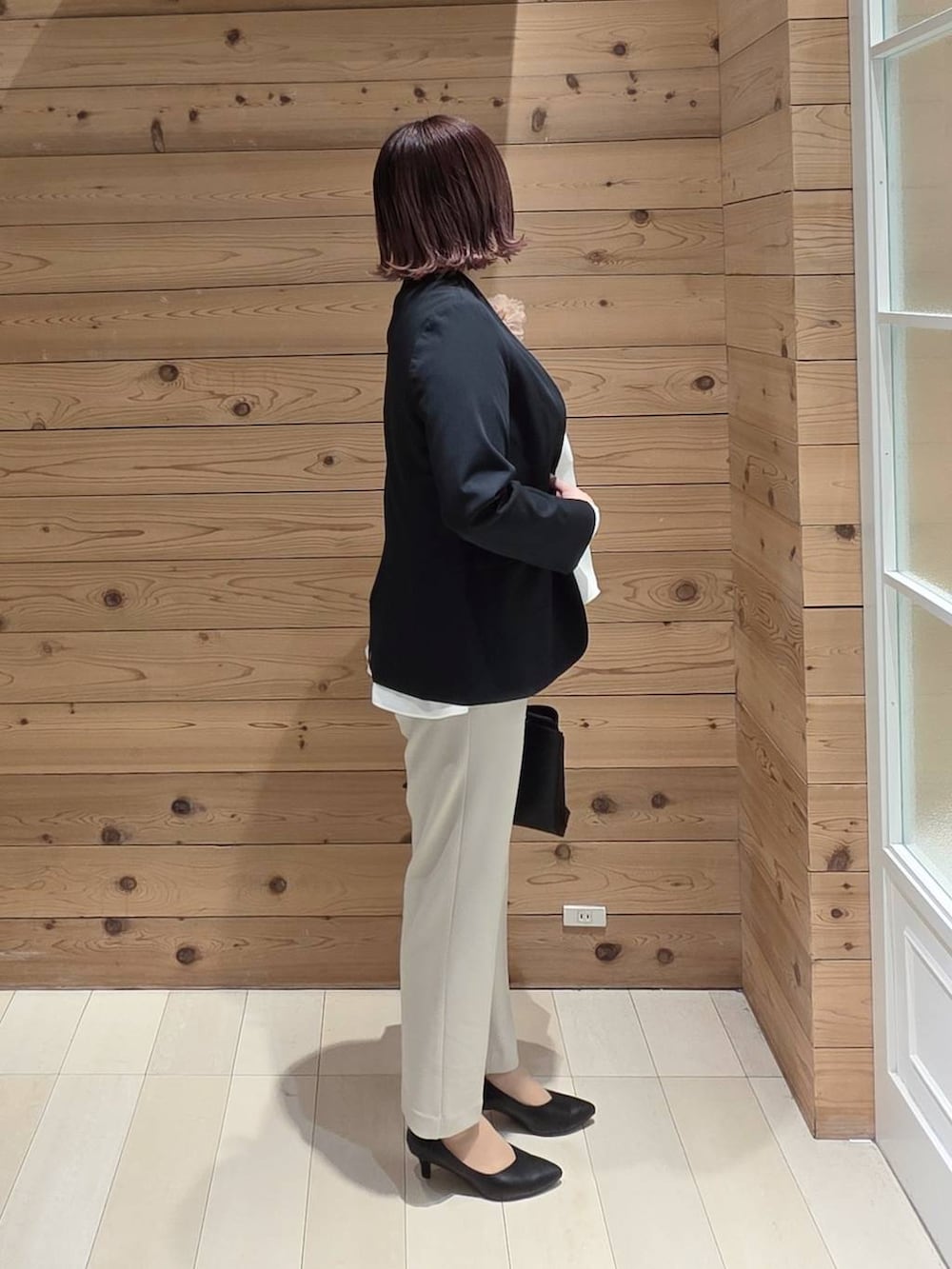 ブラック系のパンプス、ベージュ系のセットアップ、ブルー系のノーカラージャケットを着用したレディースの冬コーディネートの2枚目の写真