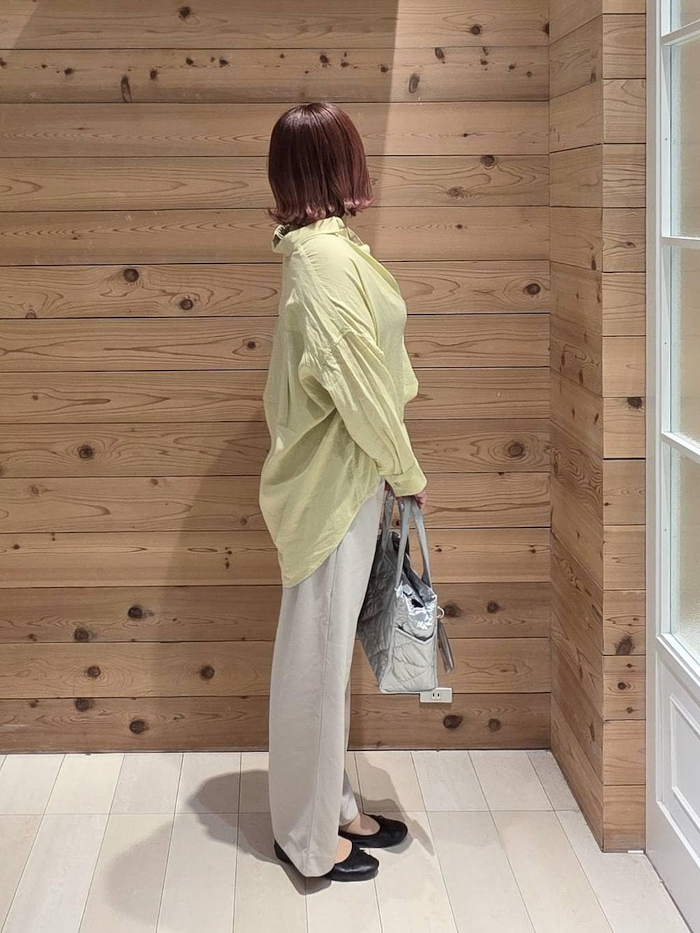 ブラック系のバレエシューズ、シルバー系のトートバッグ、イエロー系のシャツ/ブラウスを着用したレディースの春コーディネートの2枚目の写真