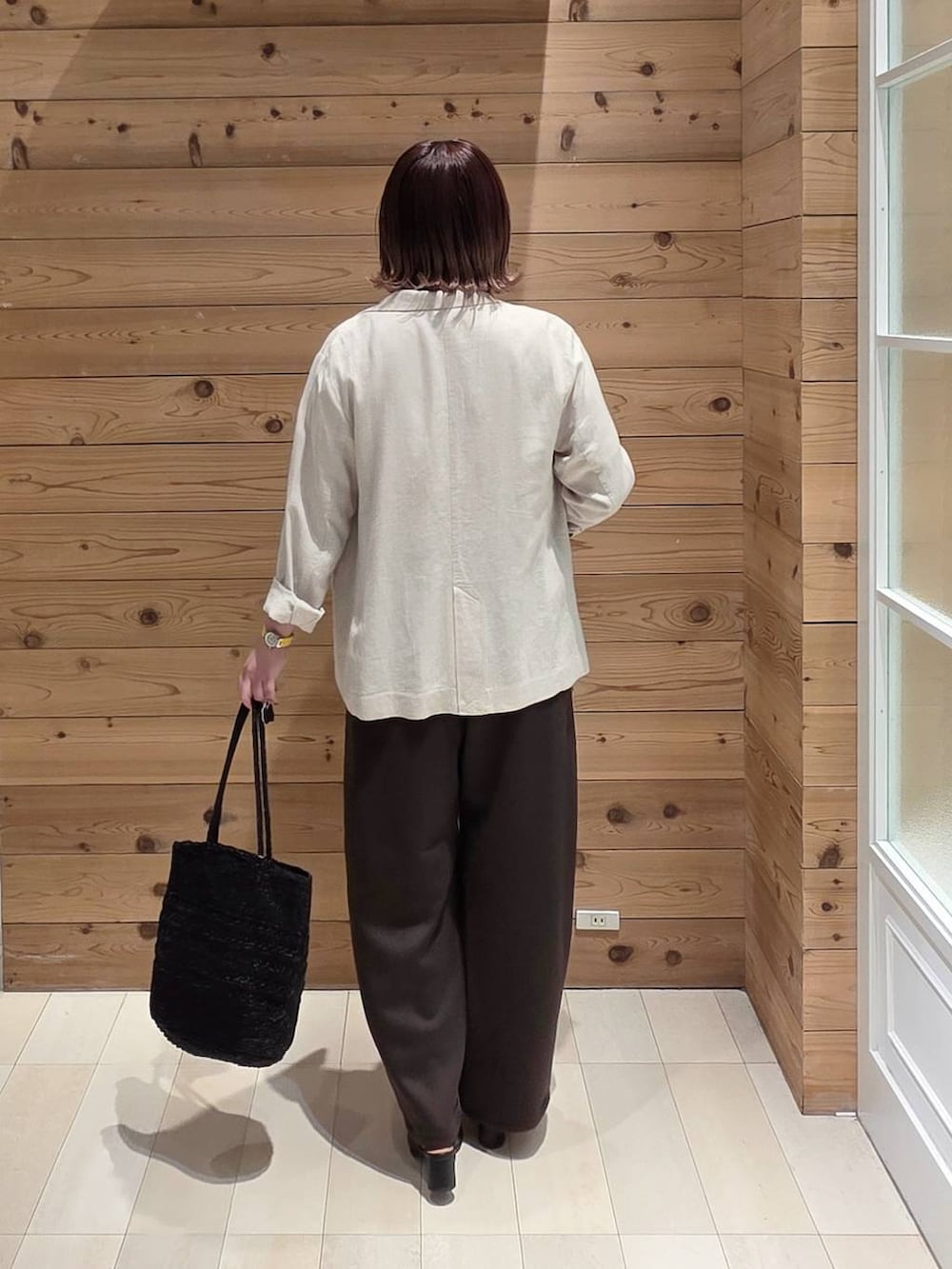 ベージュ系のテーラードジャケット、ホワイト系のTシャツ/カットソー、ブラック系のクラッチバッグを着用したレディースの春コーディネートの3枚目の写真